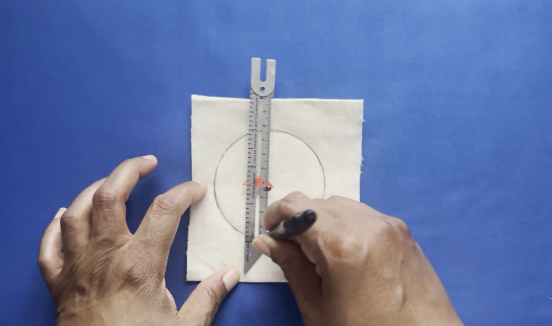 Keeping the pin firmly in place, carefully rotate the Sewing Gauge around it.